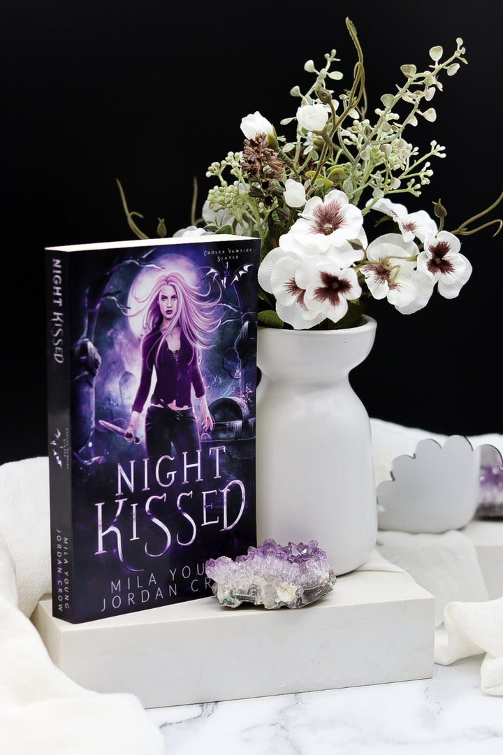 Night Kissed Paperback with a mysterious cover featuring a moonlit landscape
