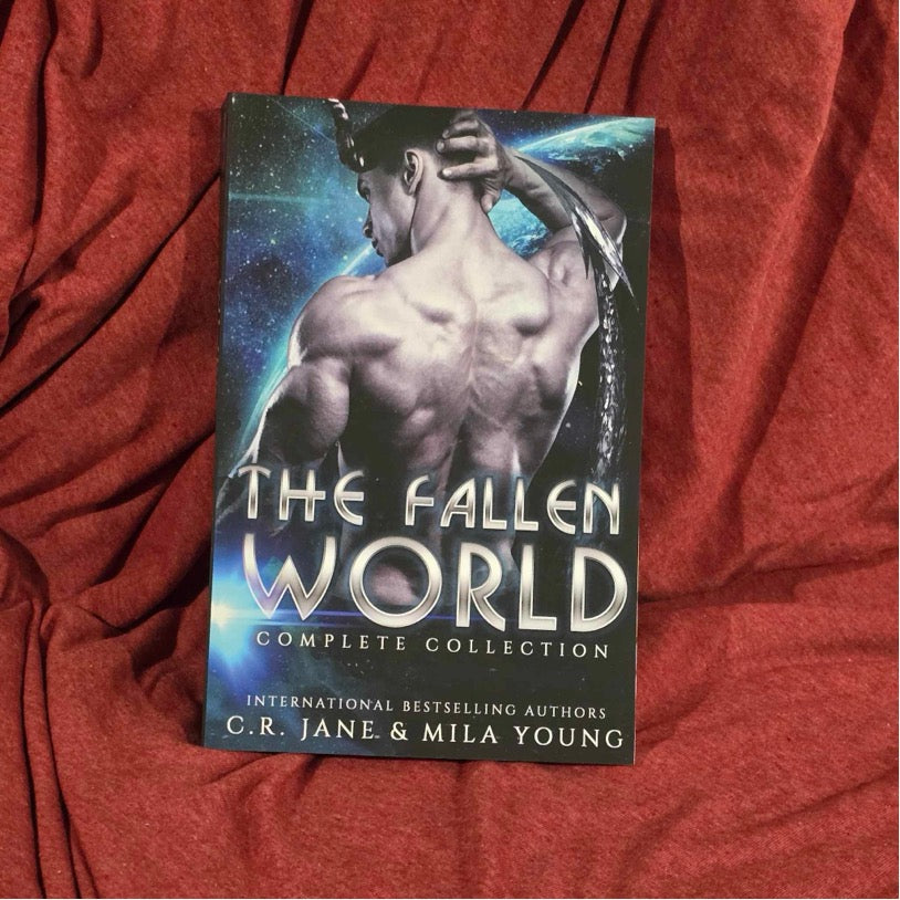 A heavily discounted, damaged US edition of the Fallen World: Complete Series featuring three alien warriors and a human woman, depicting a fiery cover with intense action and romance themes, including four full-length books of alien invasion, heart-pounding scenes, and a guaranteed happy ending