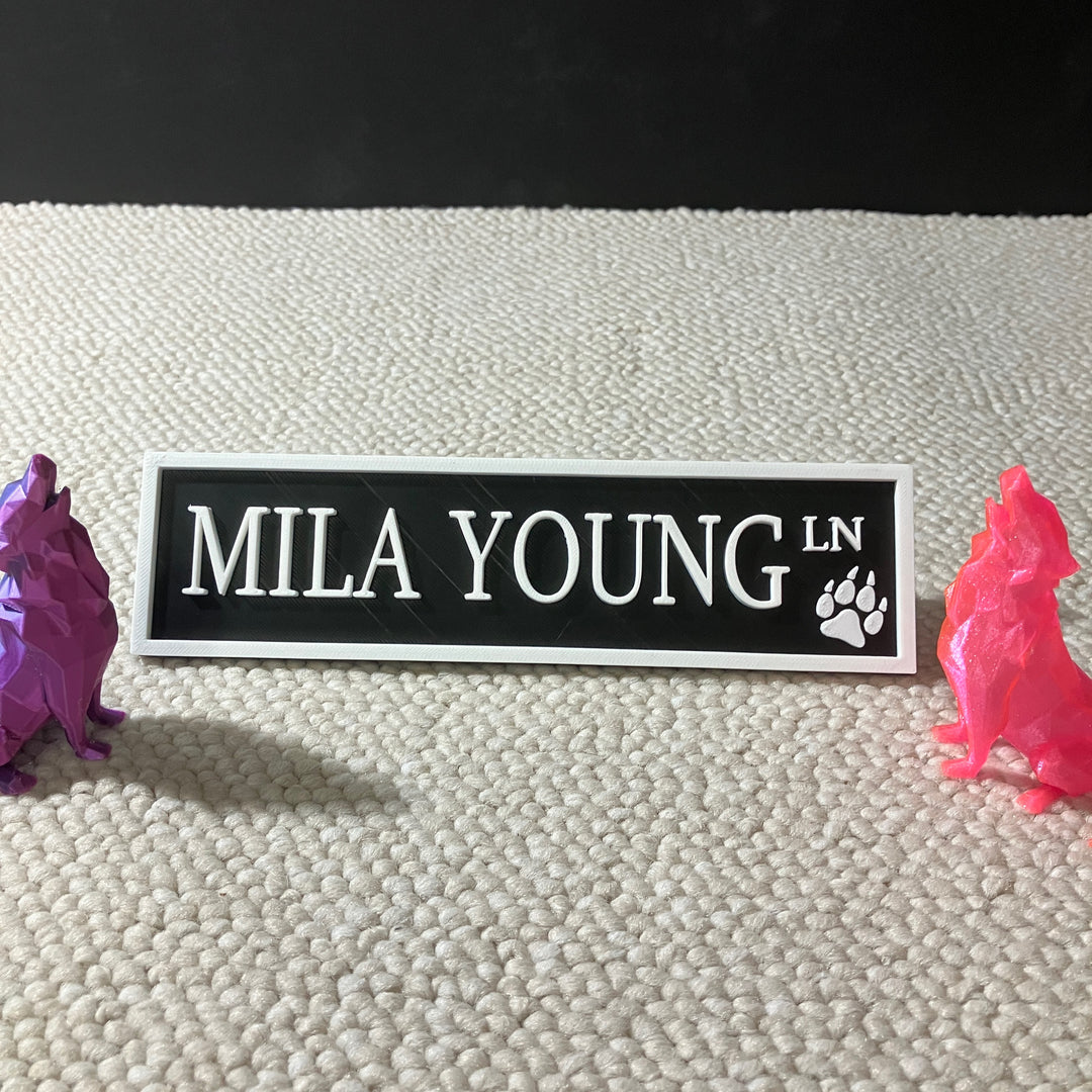 3D printed Mila Young Lane street sign in vibrant red colour displayed on a bookshelf