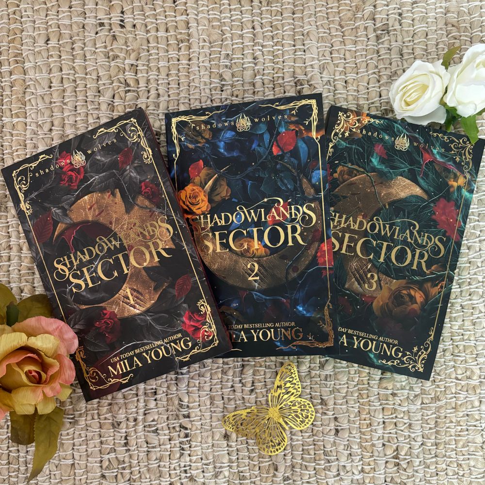 Image of the damaged Shadowlands Sector 3 paperback set featuring three books with foiled covers, metallic sprayed coloured edges, and included exclusive goodies like stickers, a foiled bookmark, and a Mila Young postcard, all shipped from the United States